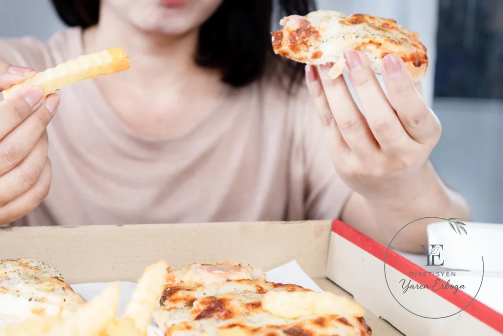 Pizza ve patates kızartması yiyen kişinin yakın plan görüntüsü